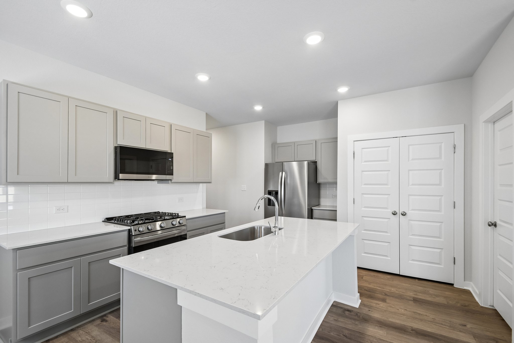 A kitchen with white cabinets.