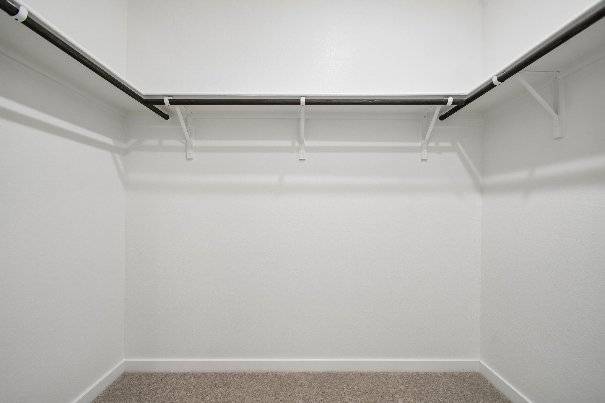 A white wall with a metal railing.