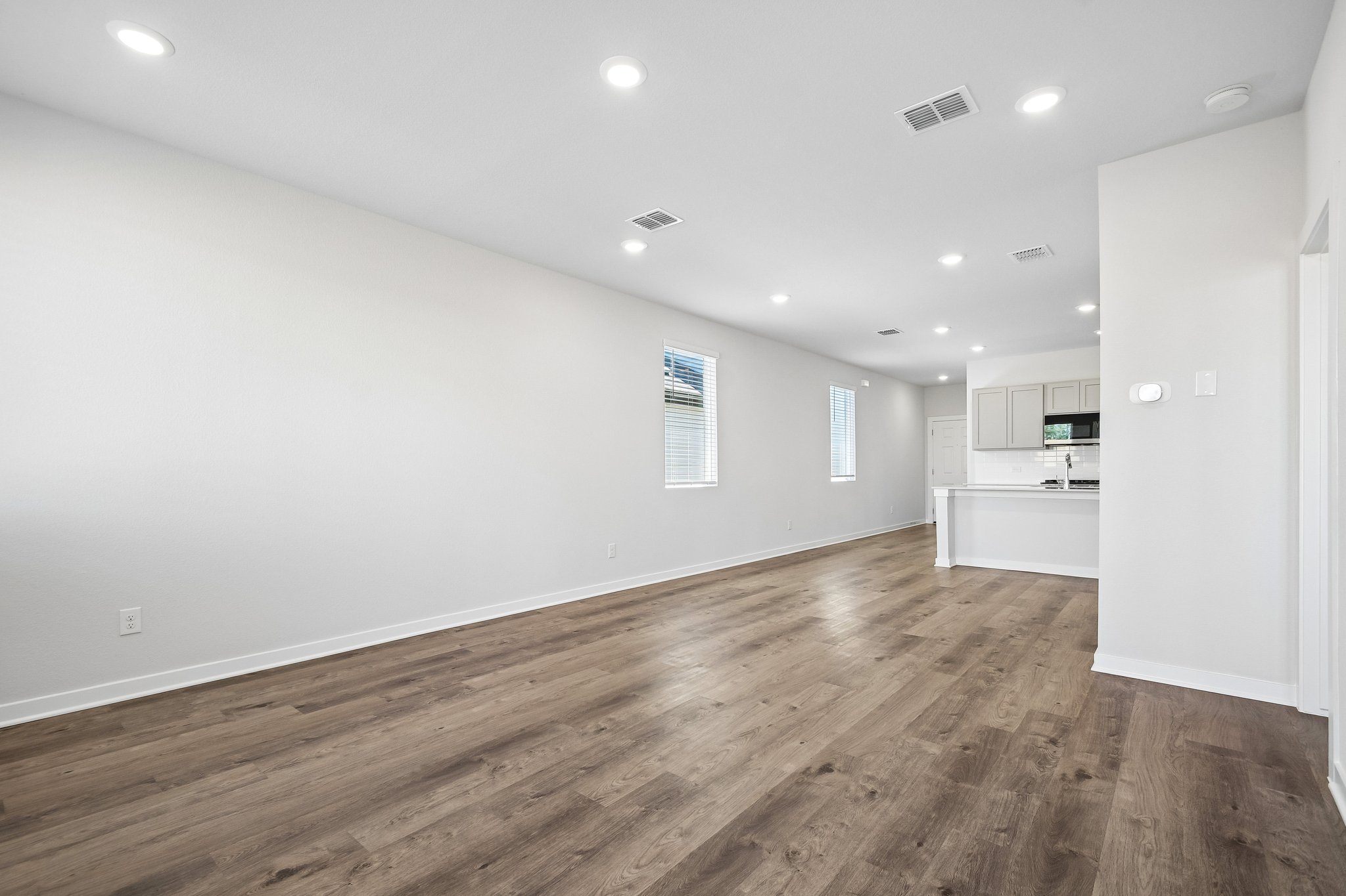 A room with a wood floor and white walls.
