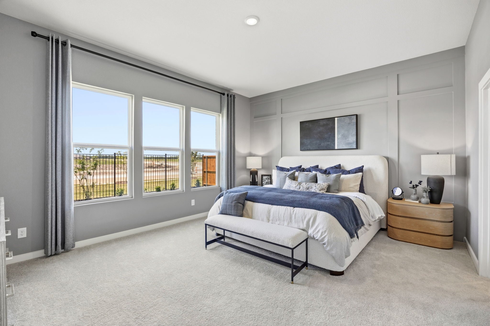 A bedroom with a bed and a bench.