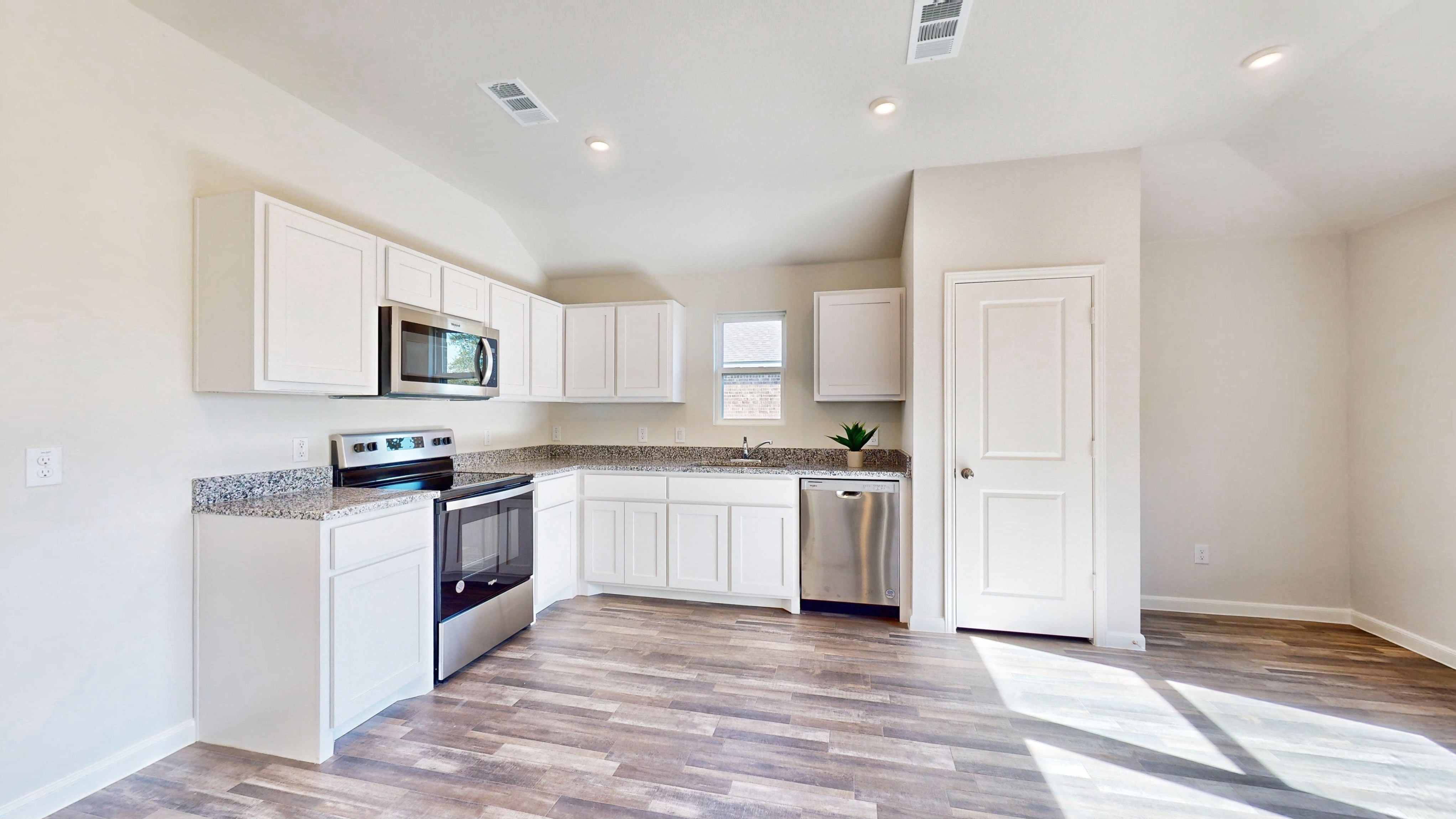 A kitchen with white cabinets.