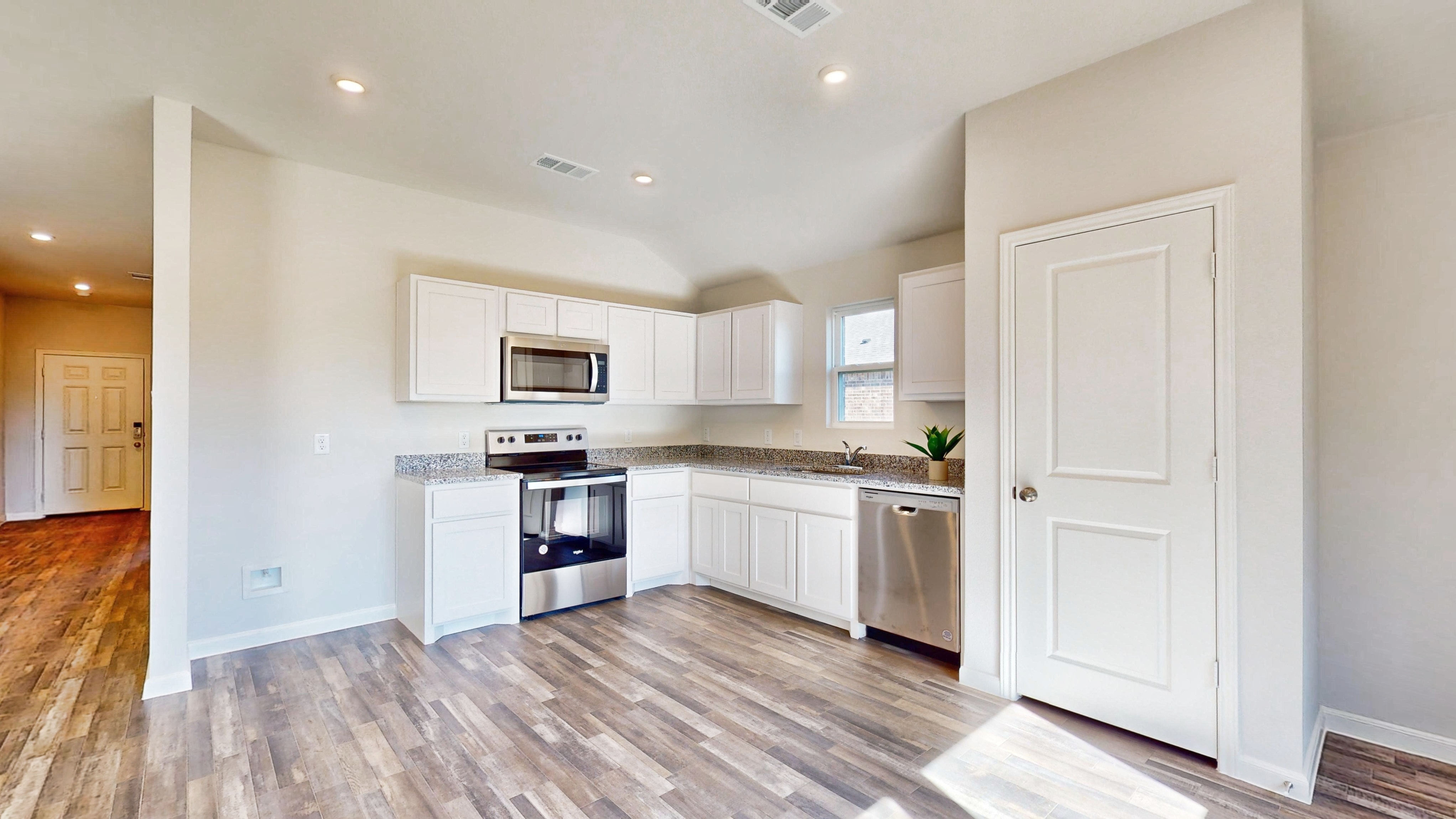 A kitchen with white cabinets.