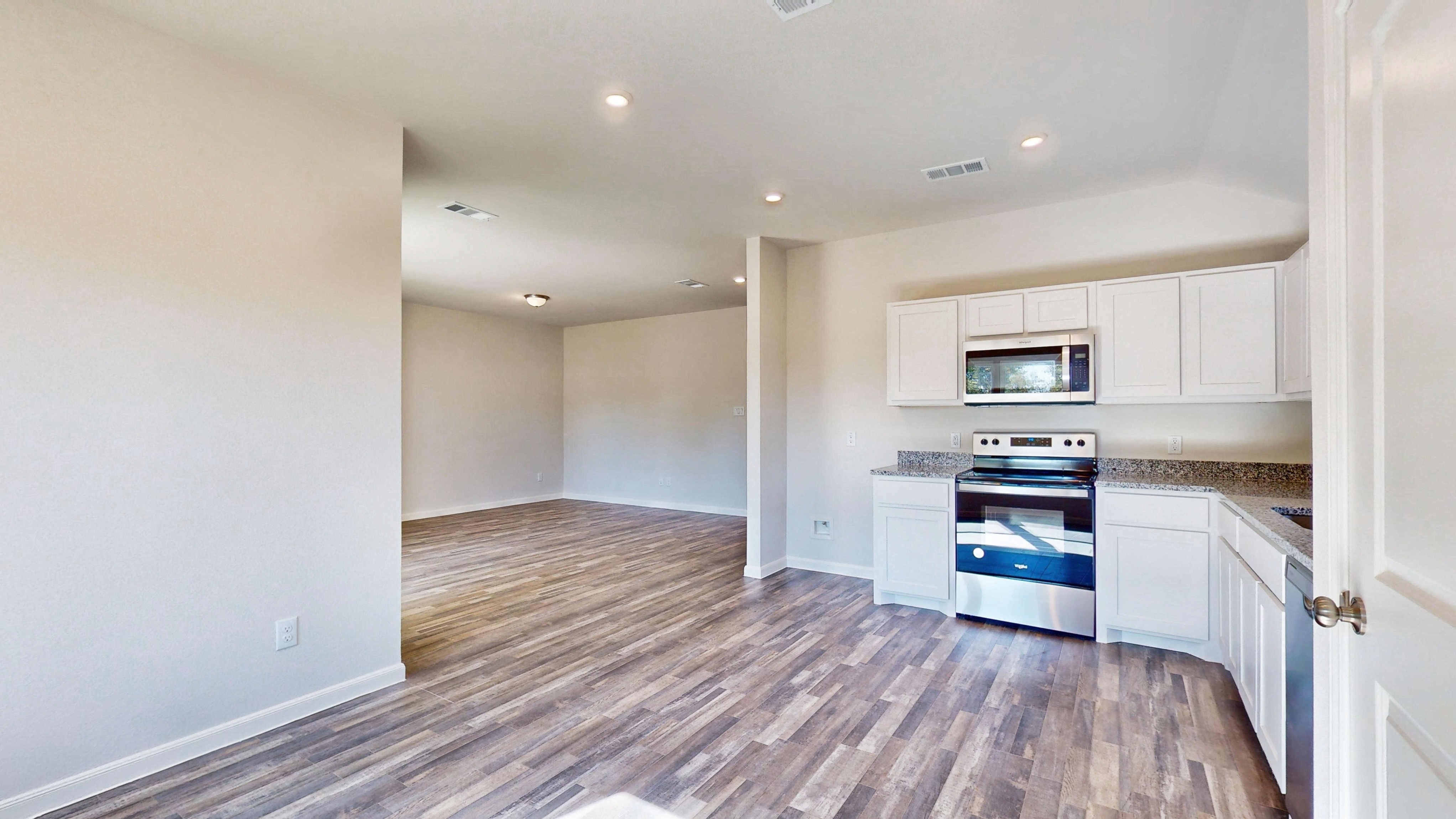 A kitchen with white cabinets.