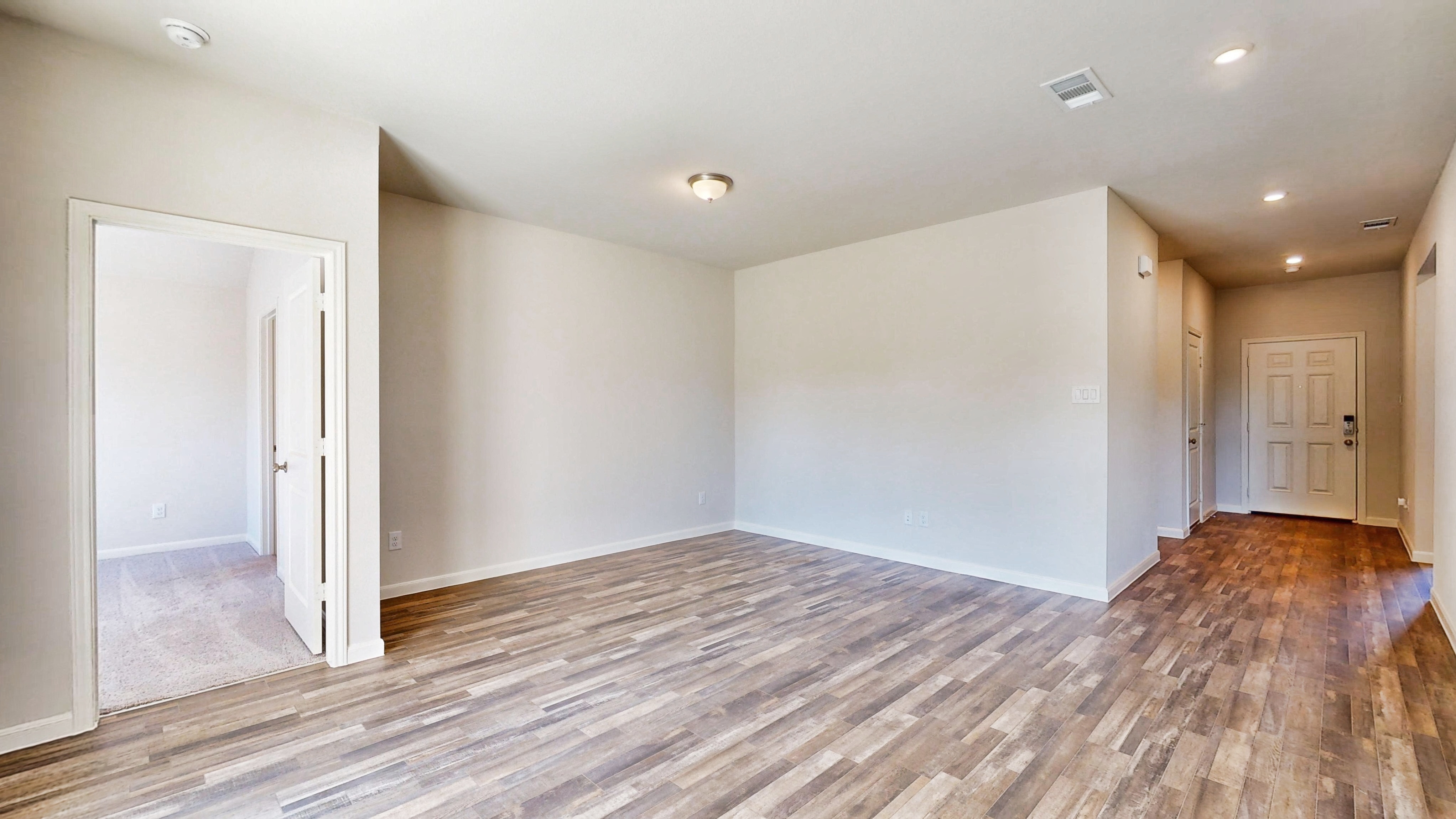 A room with white walls and wood floors.