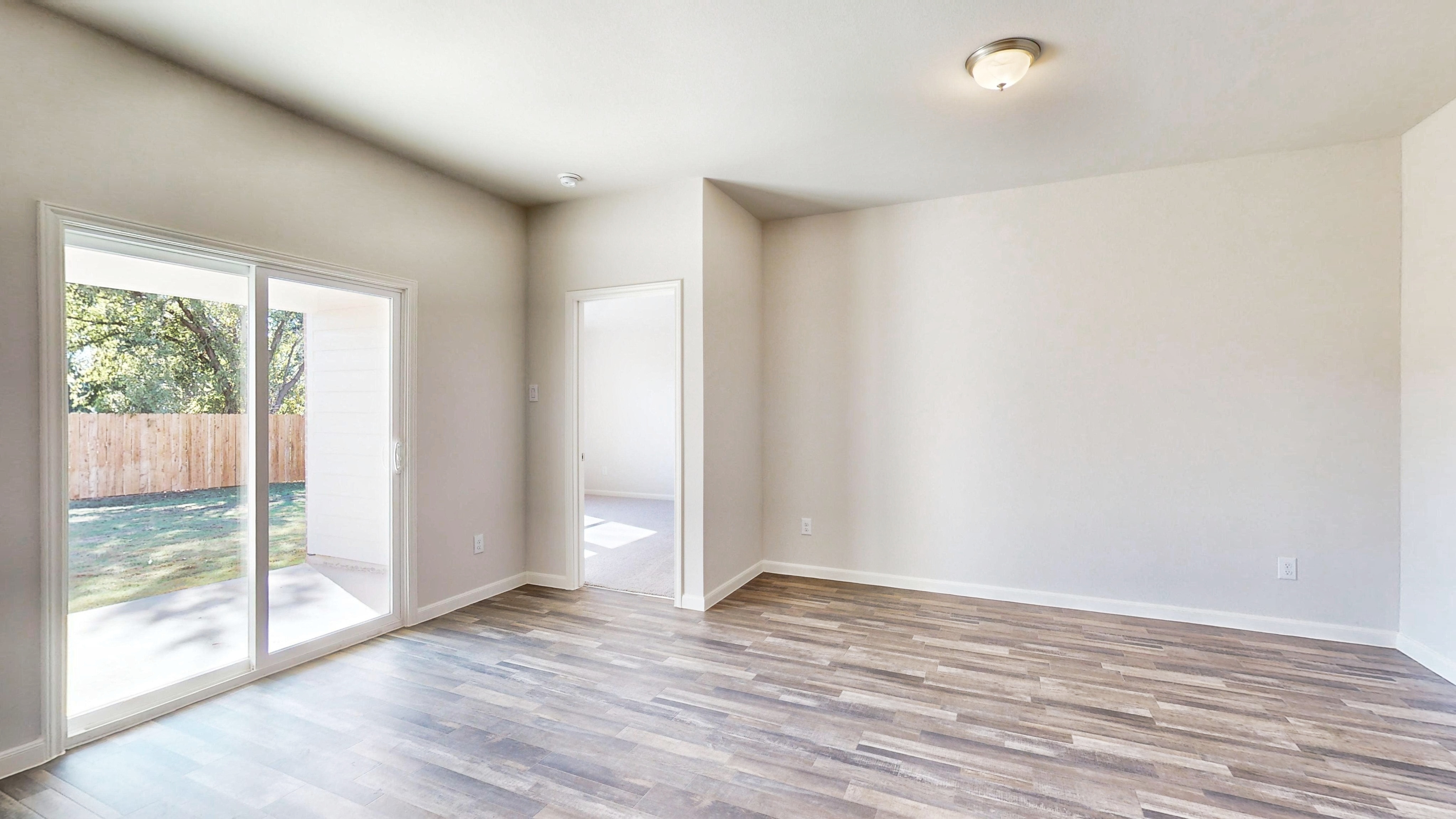 A room with a wood floor and a glass door.