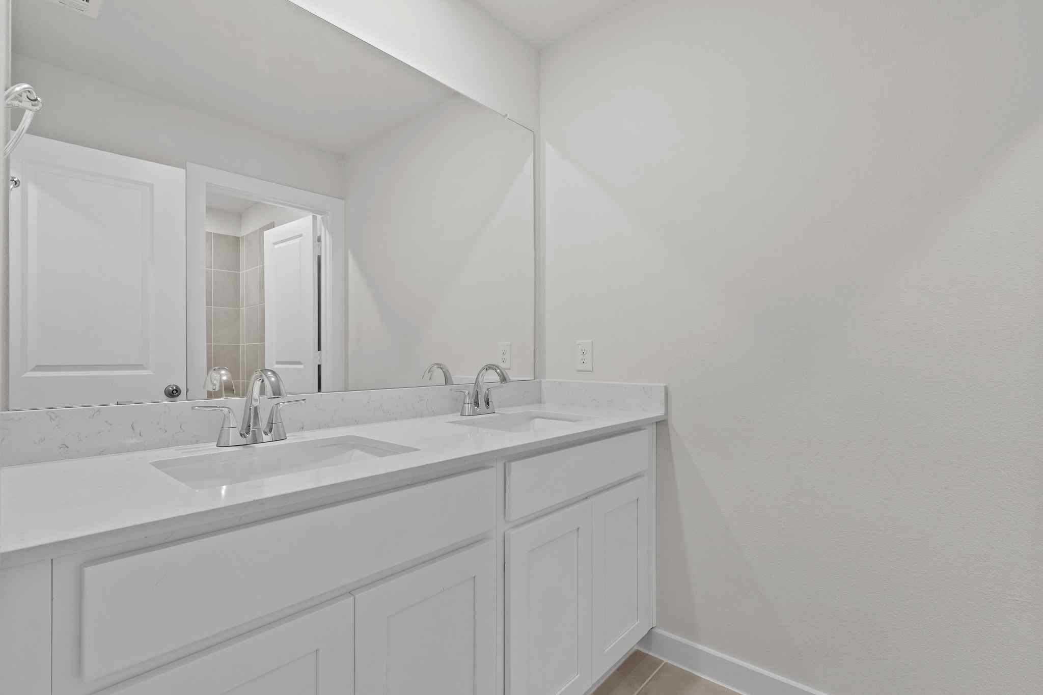 A bathroom with white cabinets.
