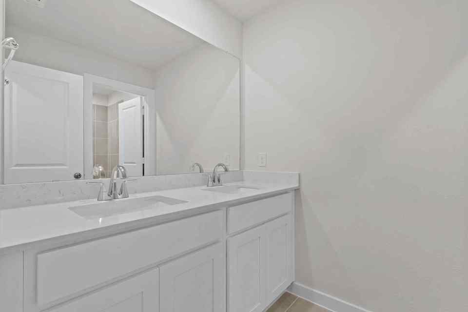 A bathroom with white cabinets.