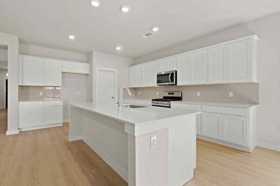 A kitchen with white cabinets.