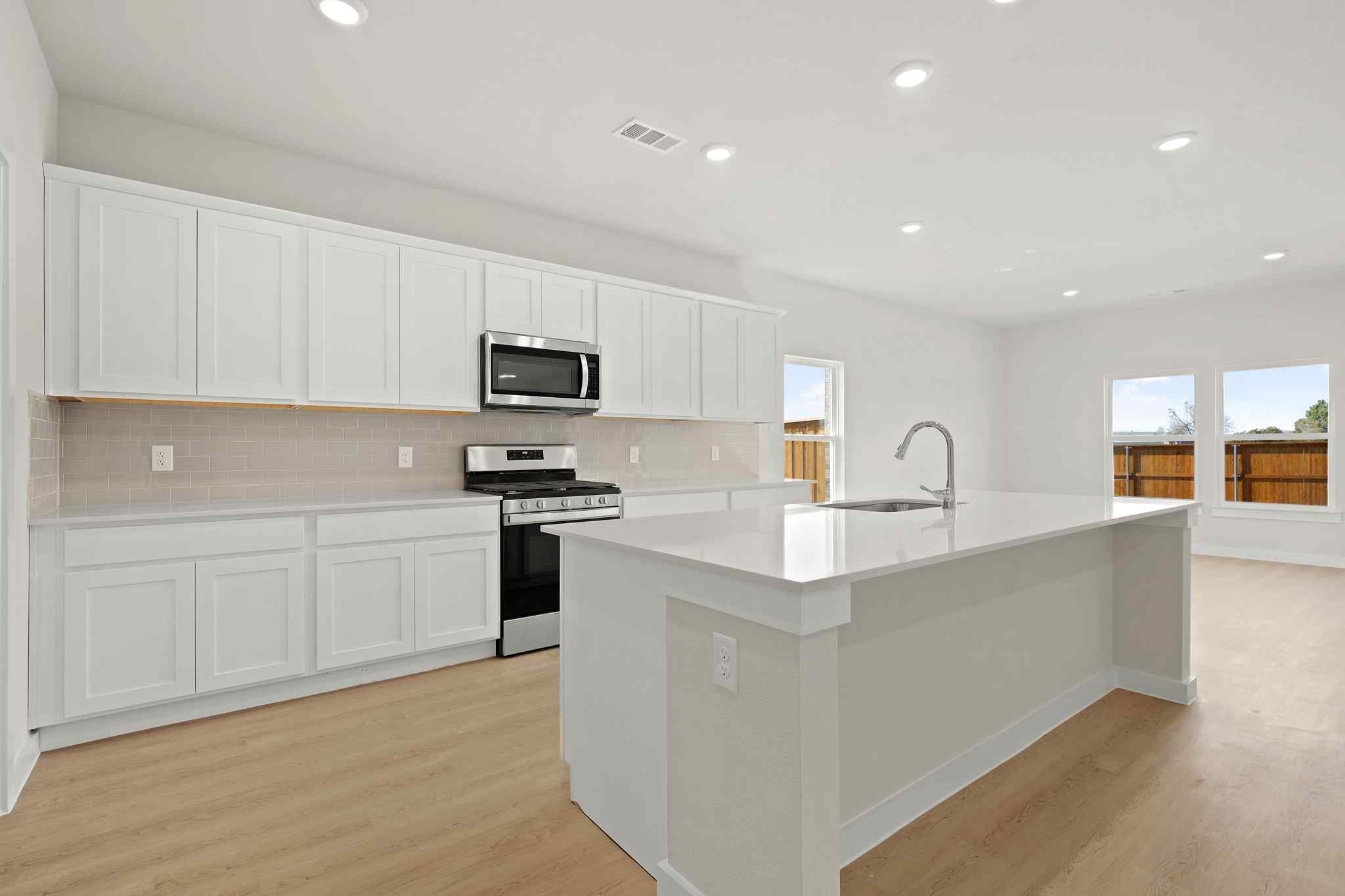 A kitchen with white cabinets.