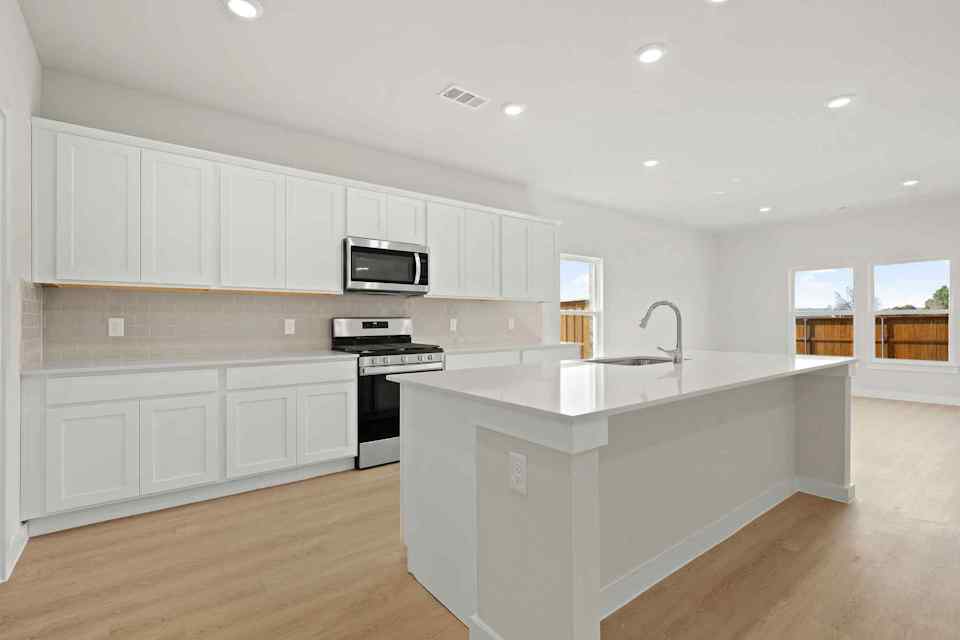 A kitchen with white cabinets.
