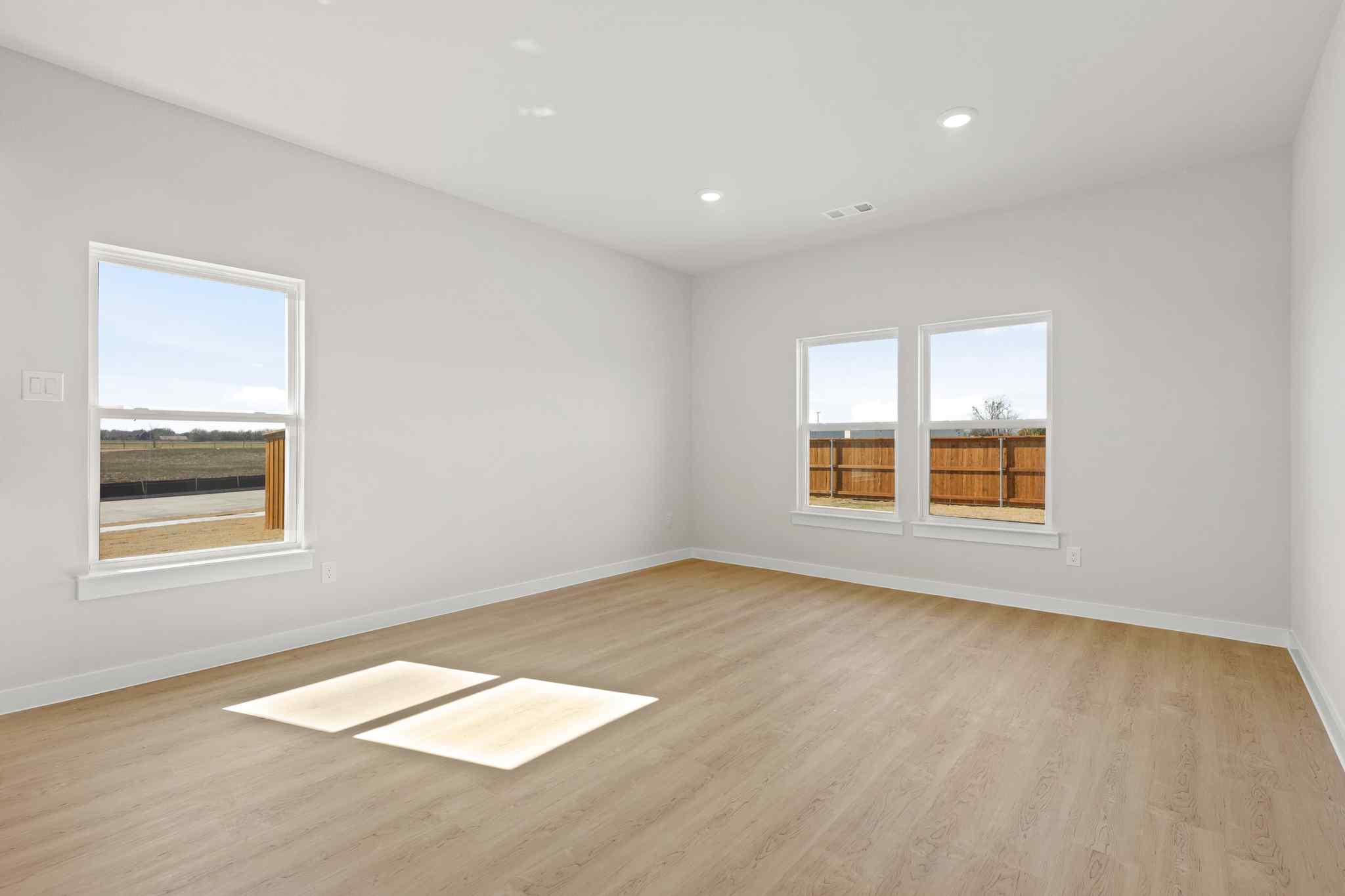A room with a wood floor and windows.
