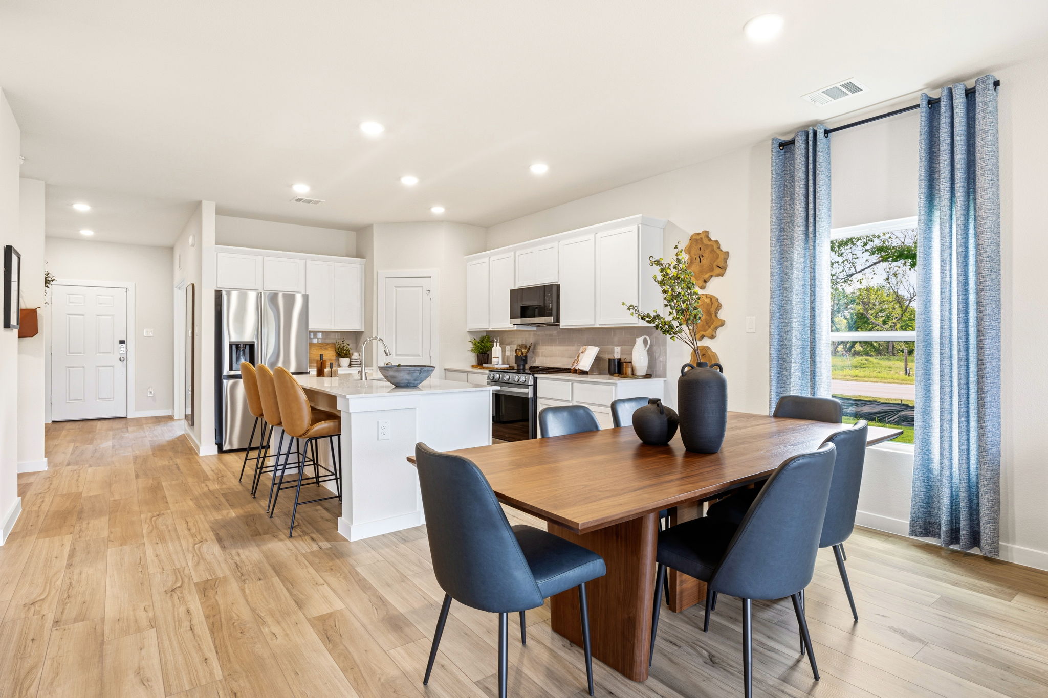 A kitchen with a dining table and chairs.