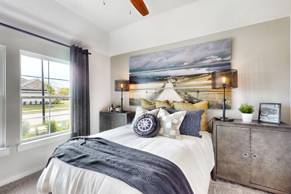 A bedroom with a large painting on the wall.