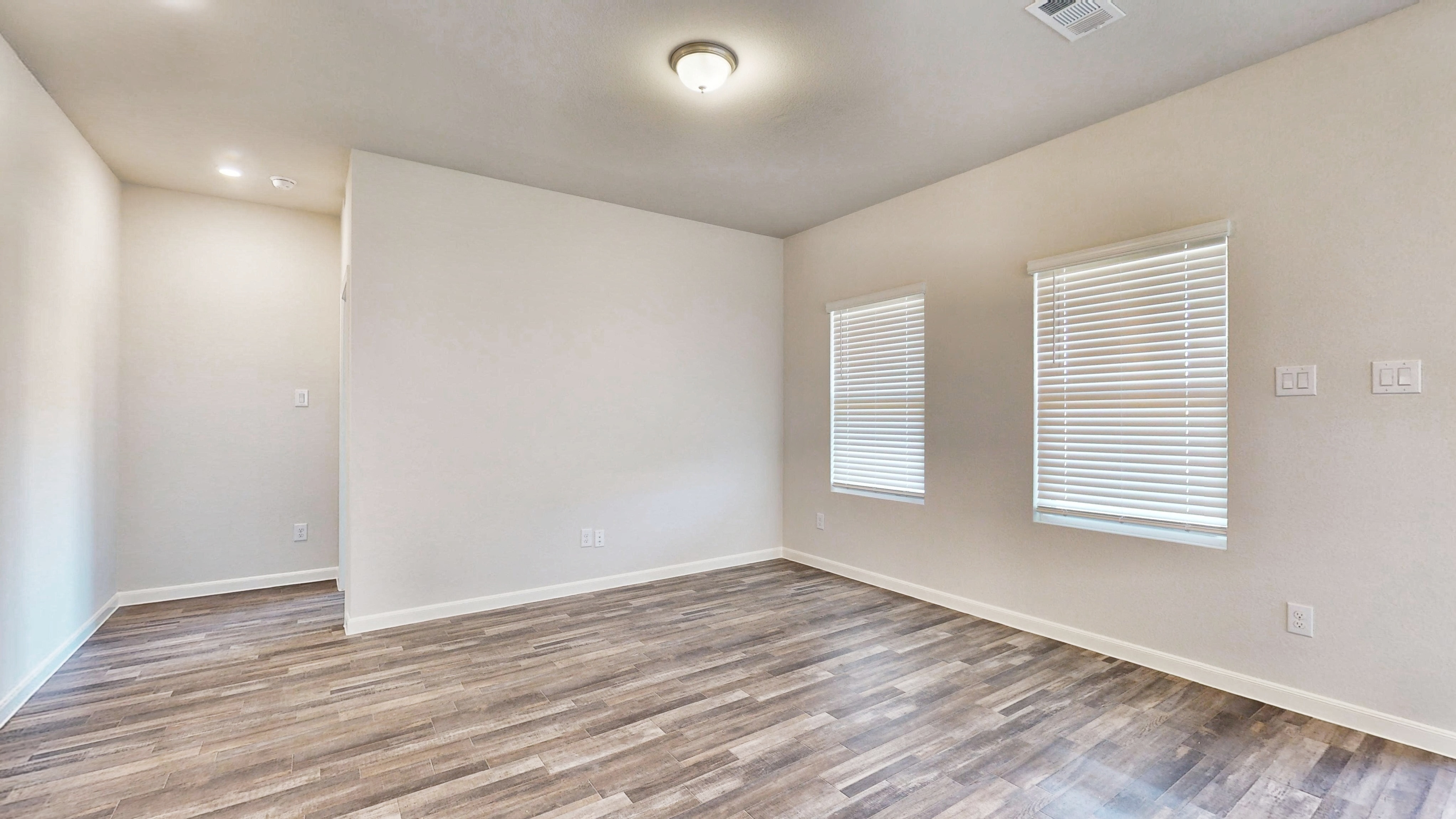 A room with a wood floor and white walls.
