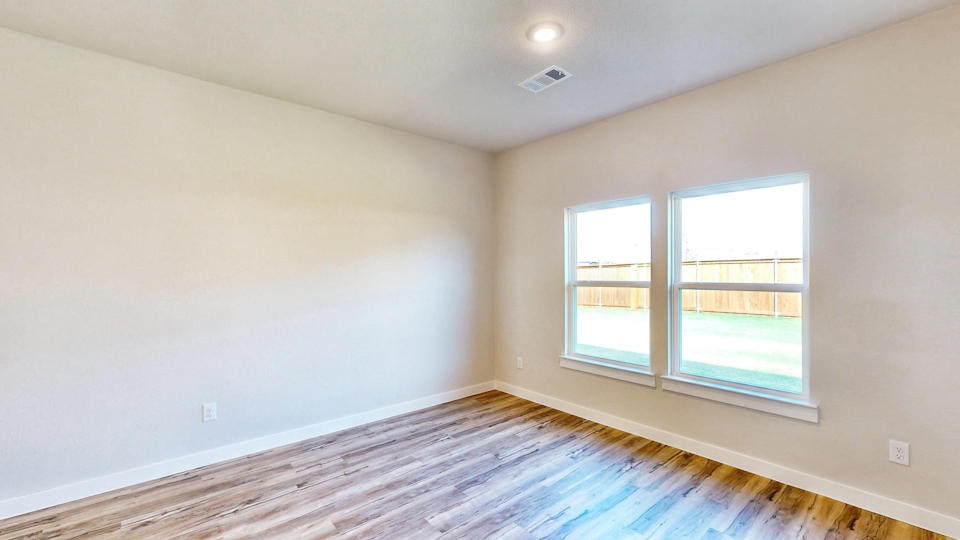A room with a window and a wood floor.