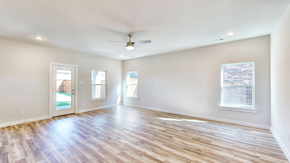 A room with a wood floor and a ceiling fan.
