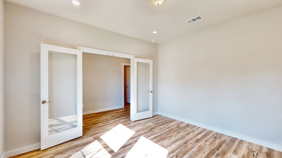 A room with a wood floor and a glass door.