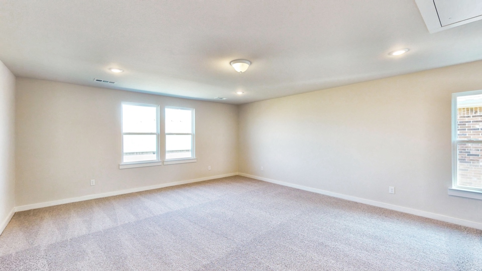 A room with a carpet and windows.