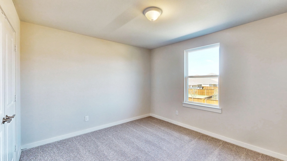 A room with a window and a carpet.