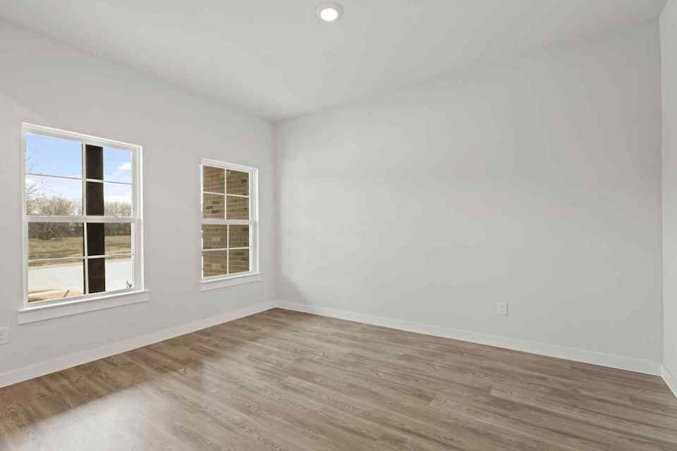 A room with a wood floor and windows.