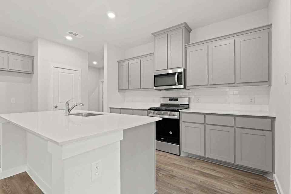 A kitchen with white cabinets.