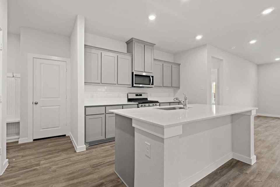 A kitchen with white cabinets.