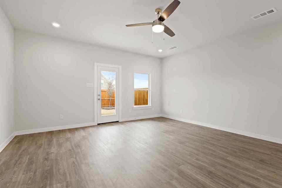A room with a wood floor and a ceiling fan.