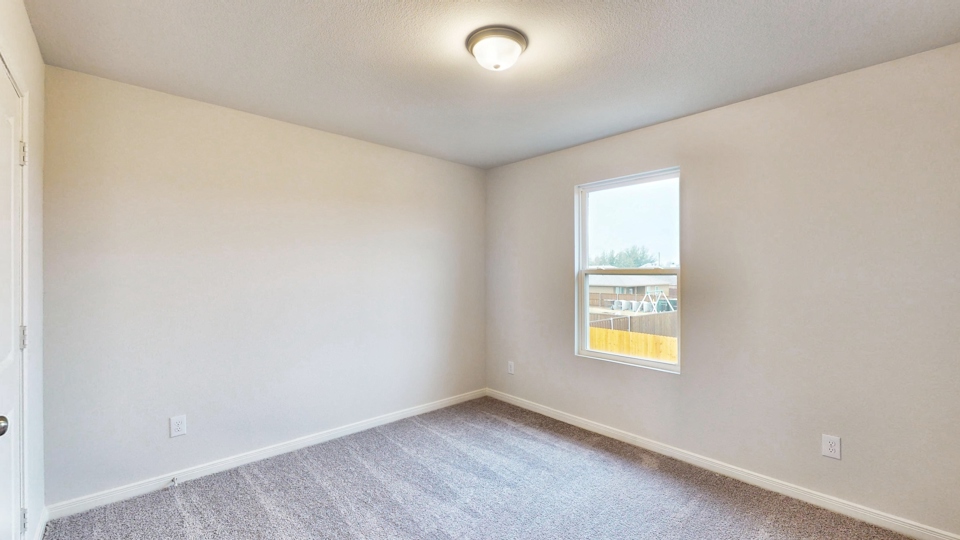 A room with a window and a carpet.