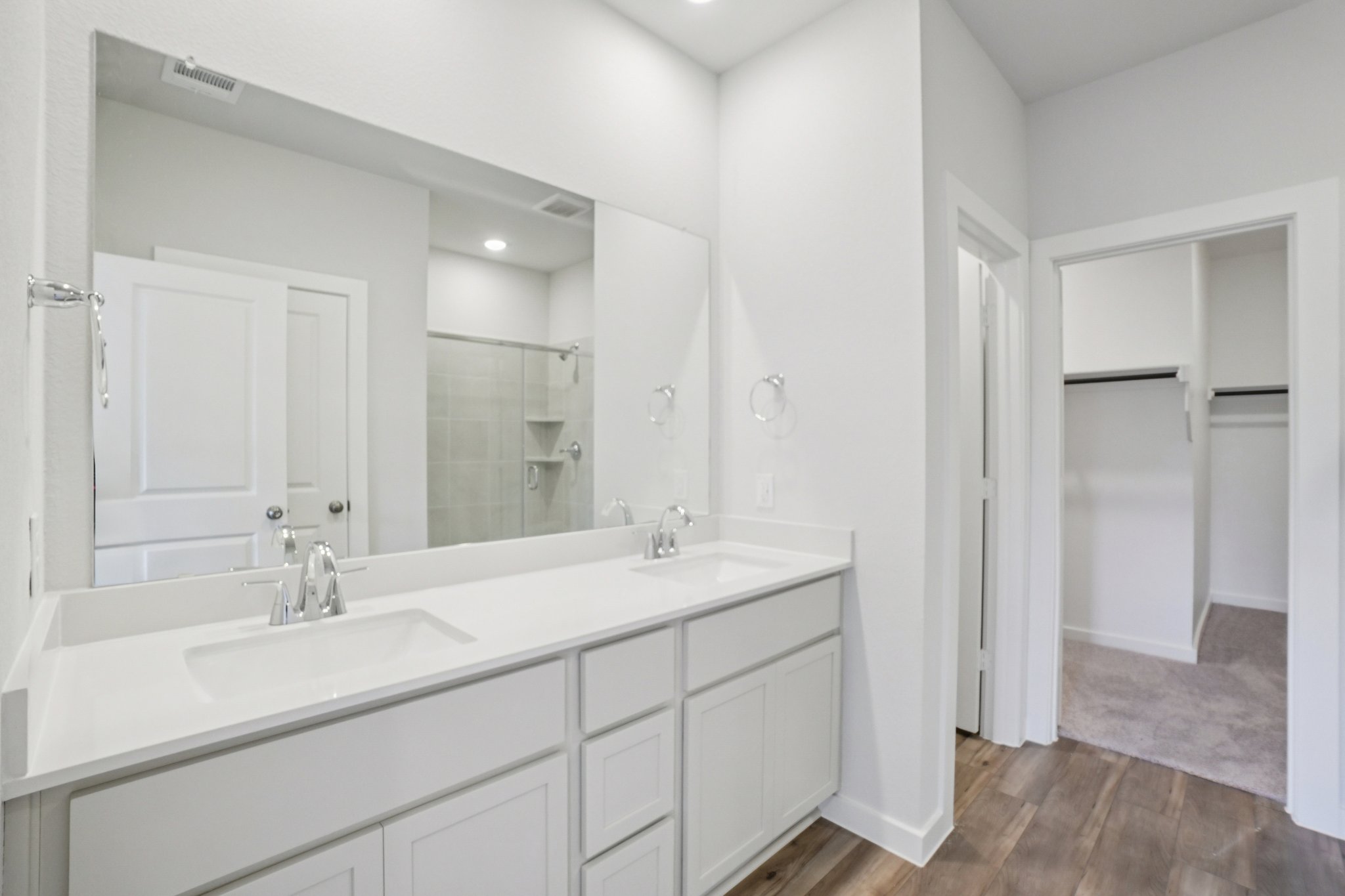 A bathroom with white cabinets.