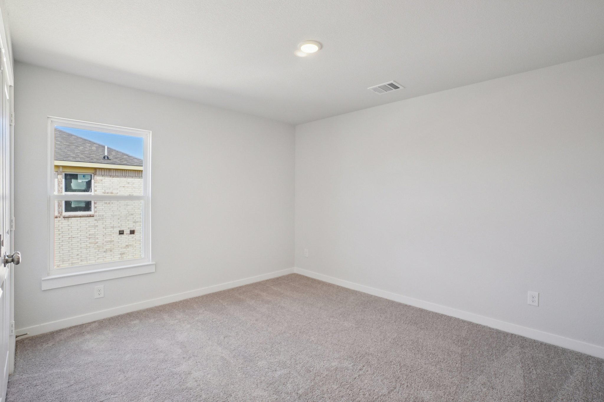 A room with a window and a carpet.