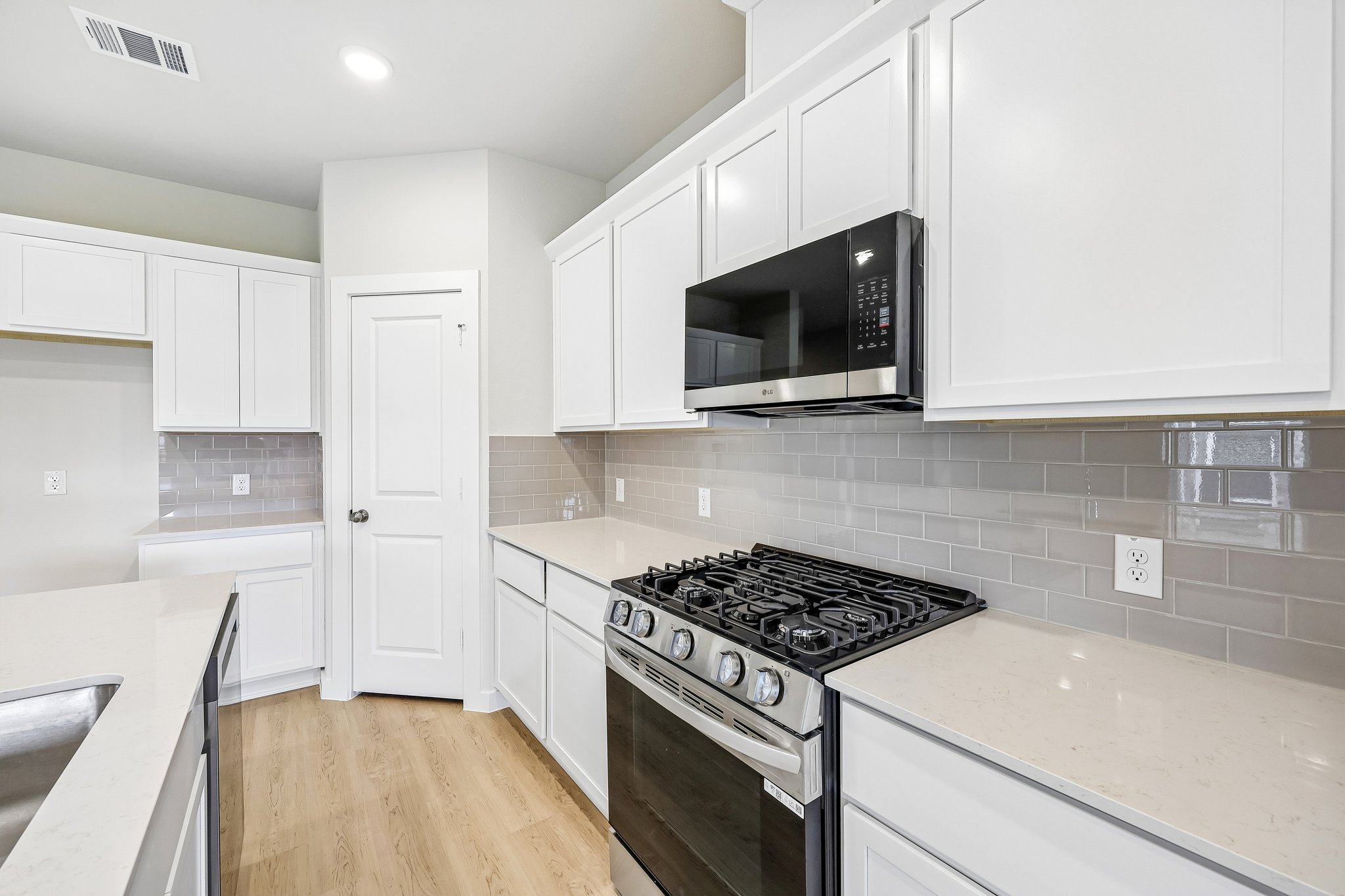 A kitchen with white cabinets.
