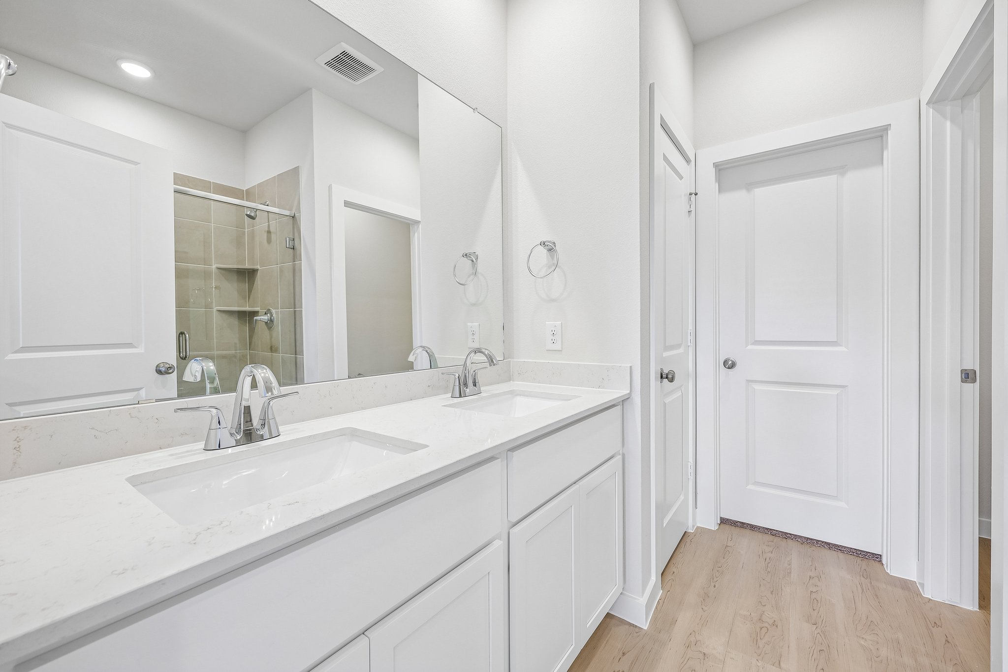 A bathroom with white cabinets.