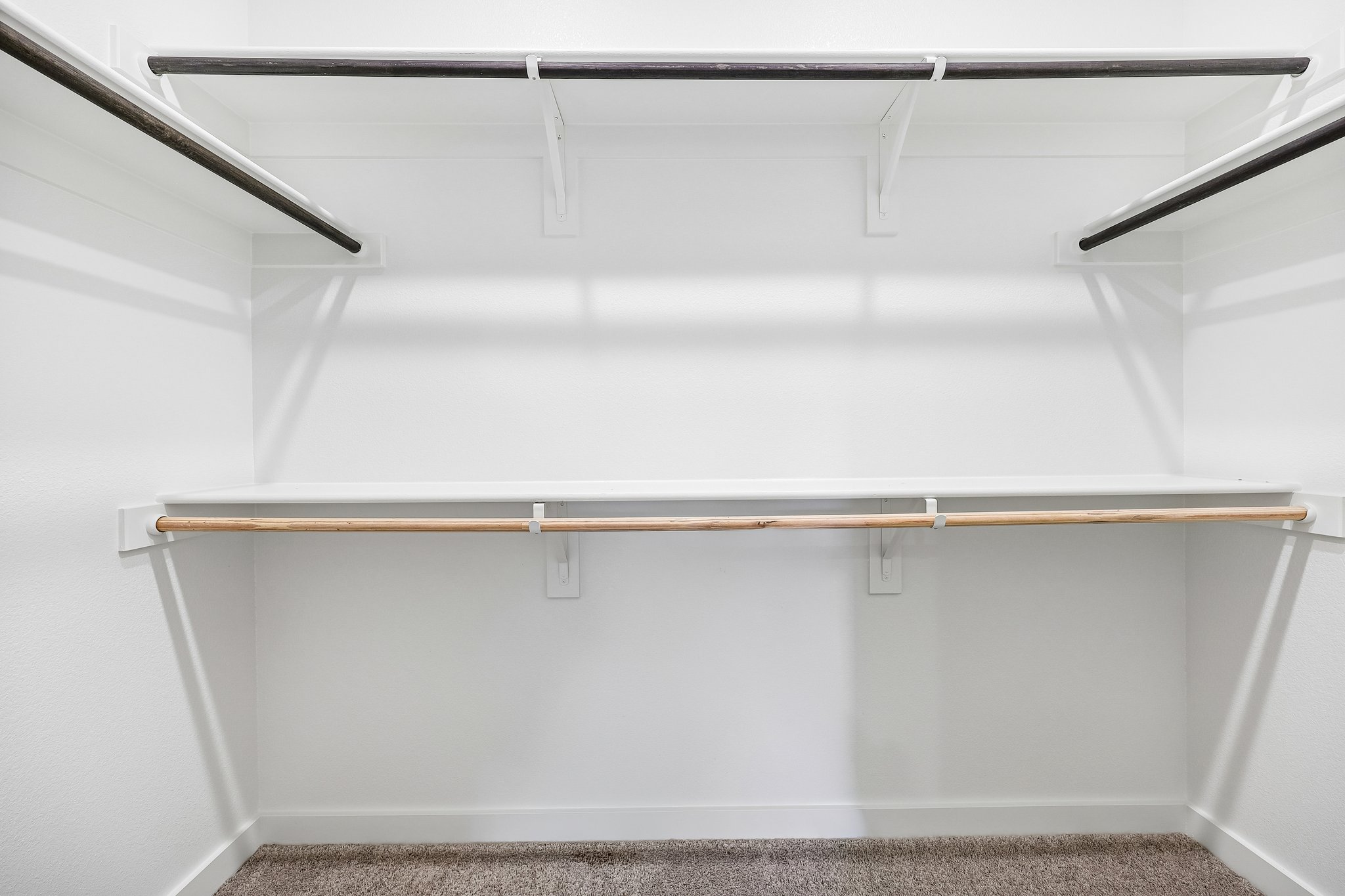 A white wall with a metal bar.