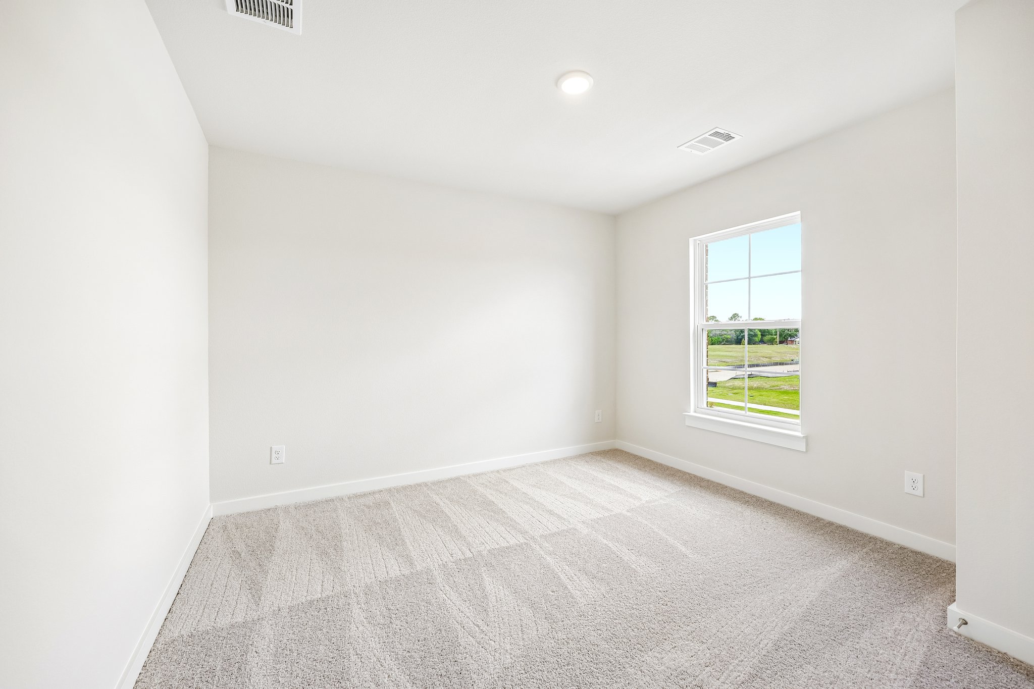 A room with a carpet and a window.