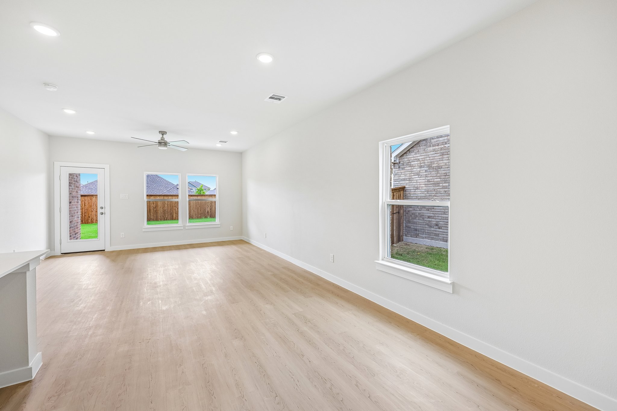 A room with a wood floor and windows.