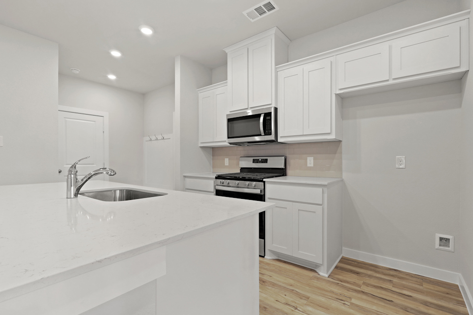 A kitchen with white cabinets.