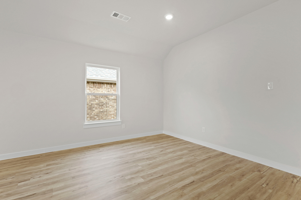 A room with a wood floor and a window.
