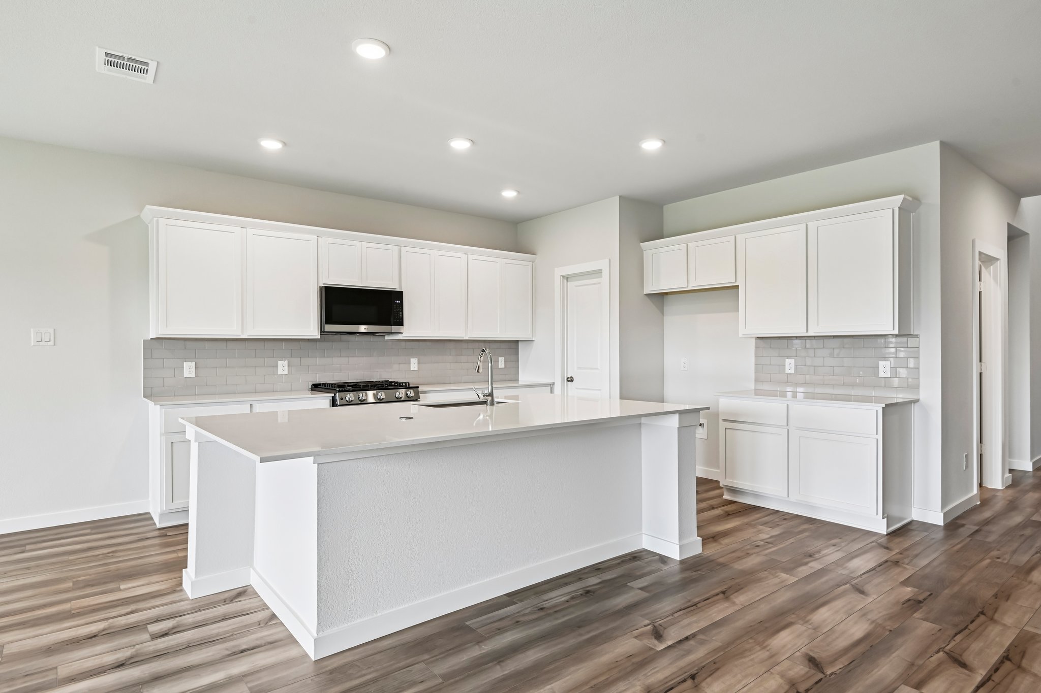 A kitchen with white cabinets.