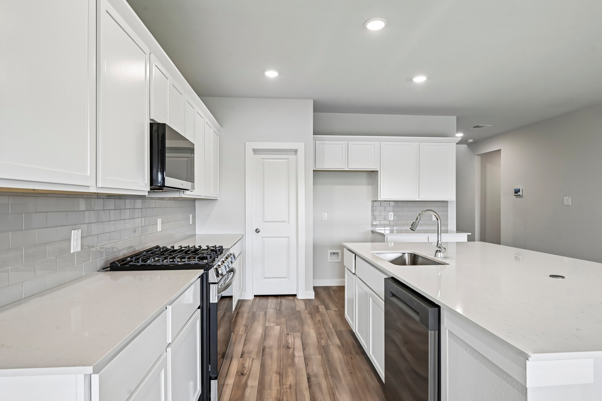 A kitchen with white cabinets.