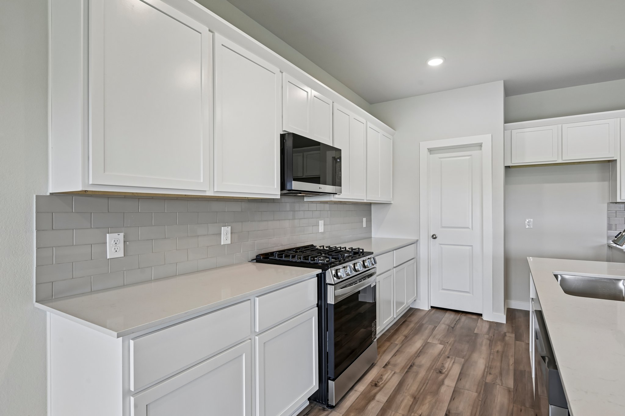 A kitchen with white cabinets.