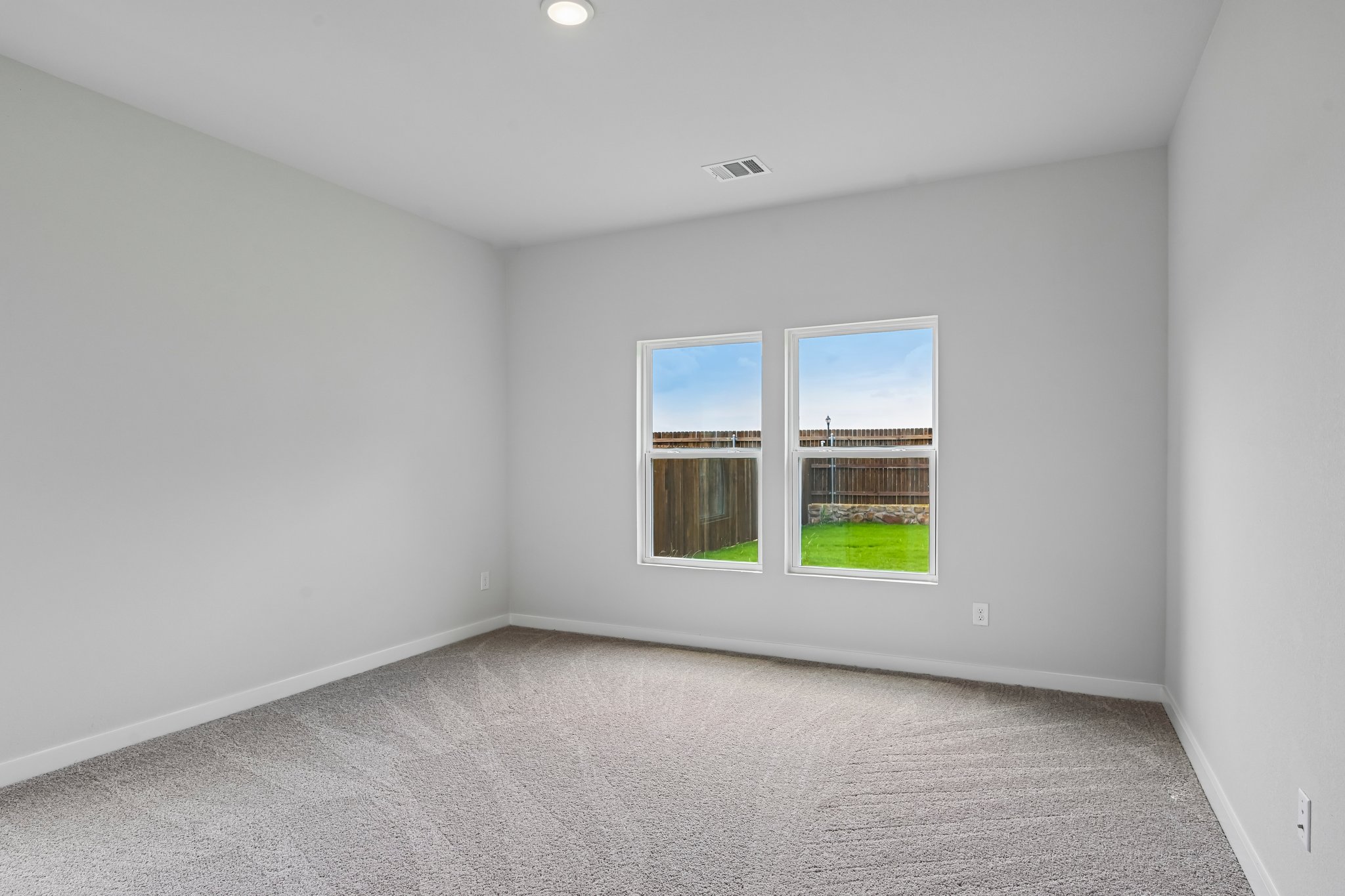 A room with a window and a carpet.