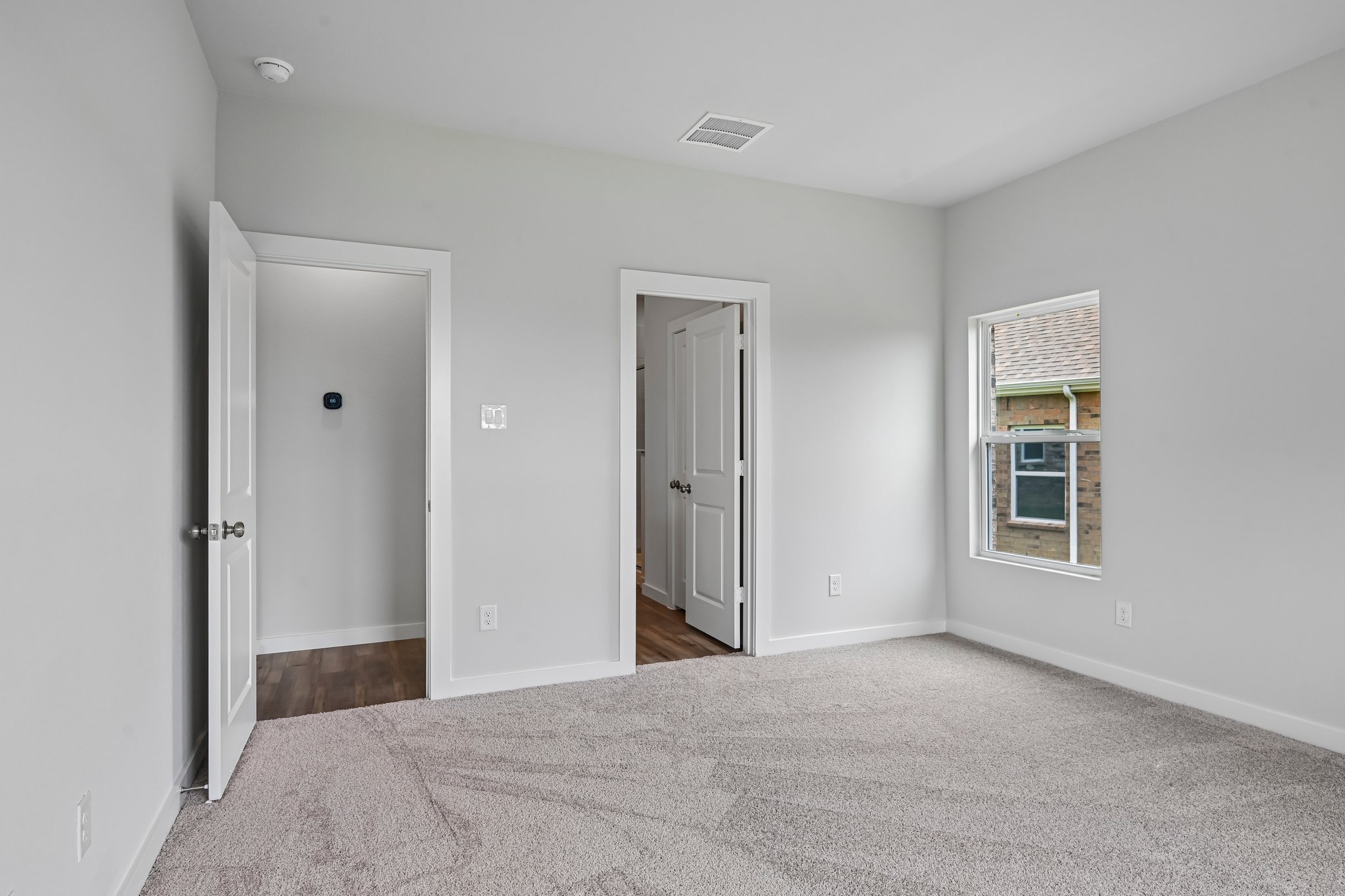 A room with a carpet and a door.