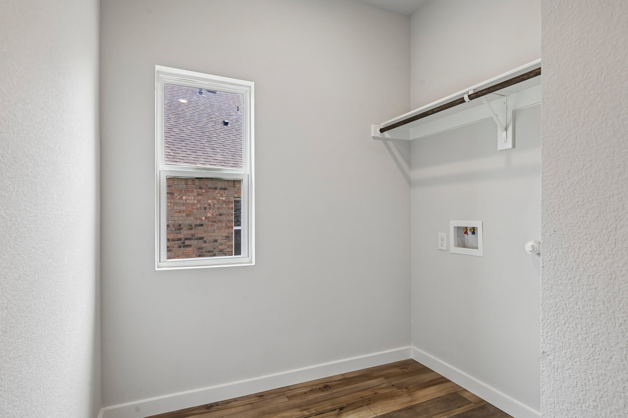 A room with a wood floor and a wood floor with a window.