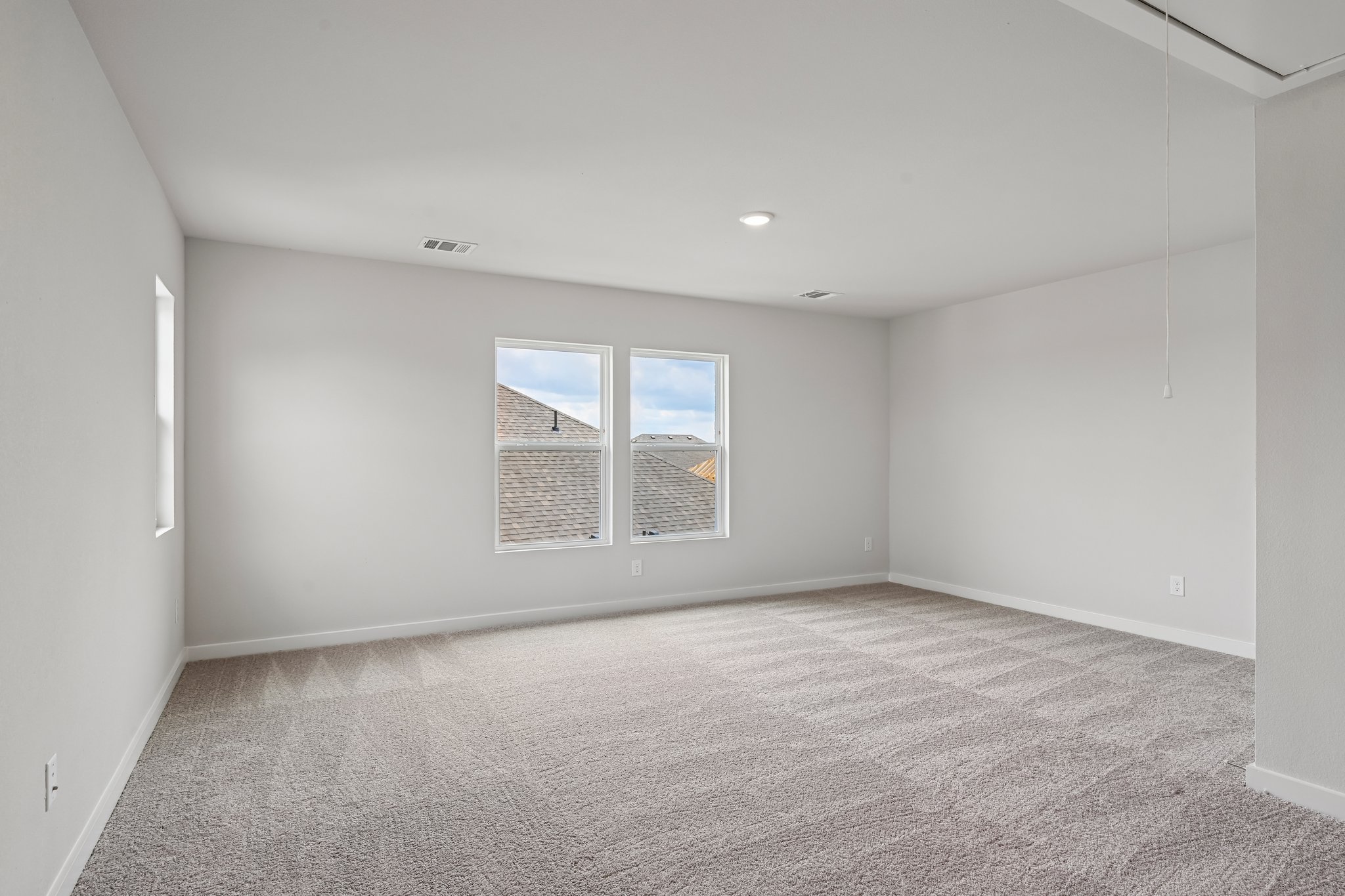 A room with a carpet and a window.
