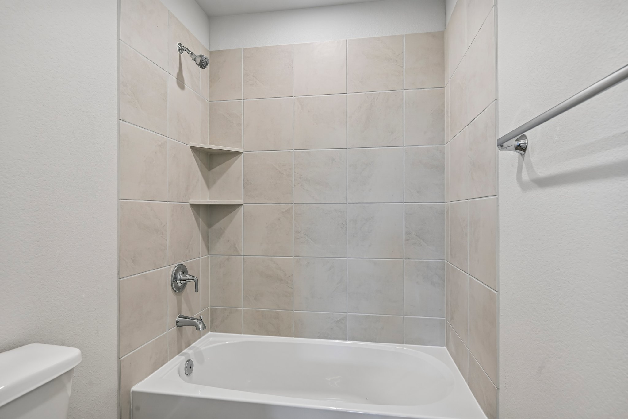 A bathroom with a bathtub and toilet.