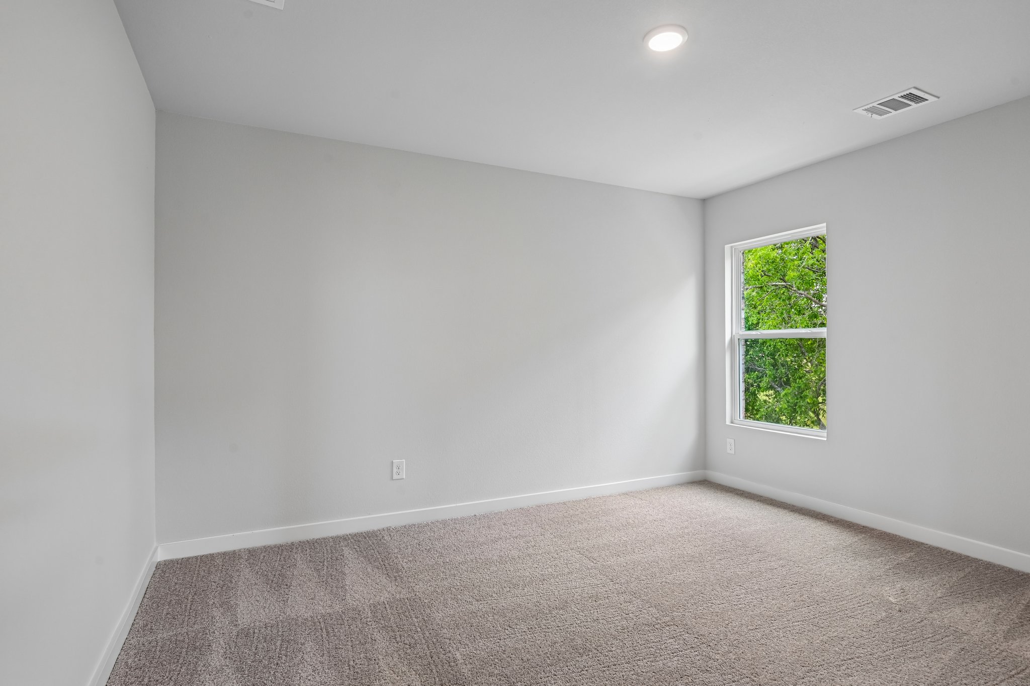 A room with a window and carpet.