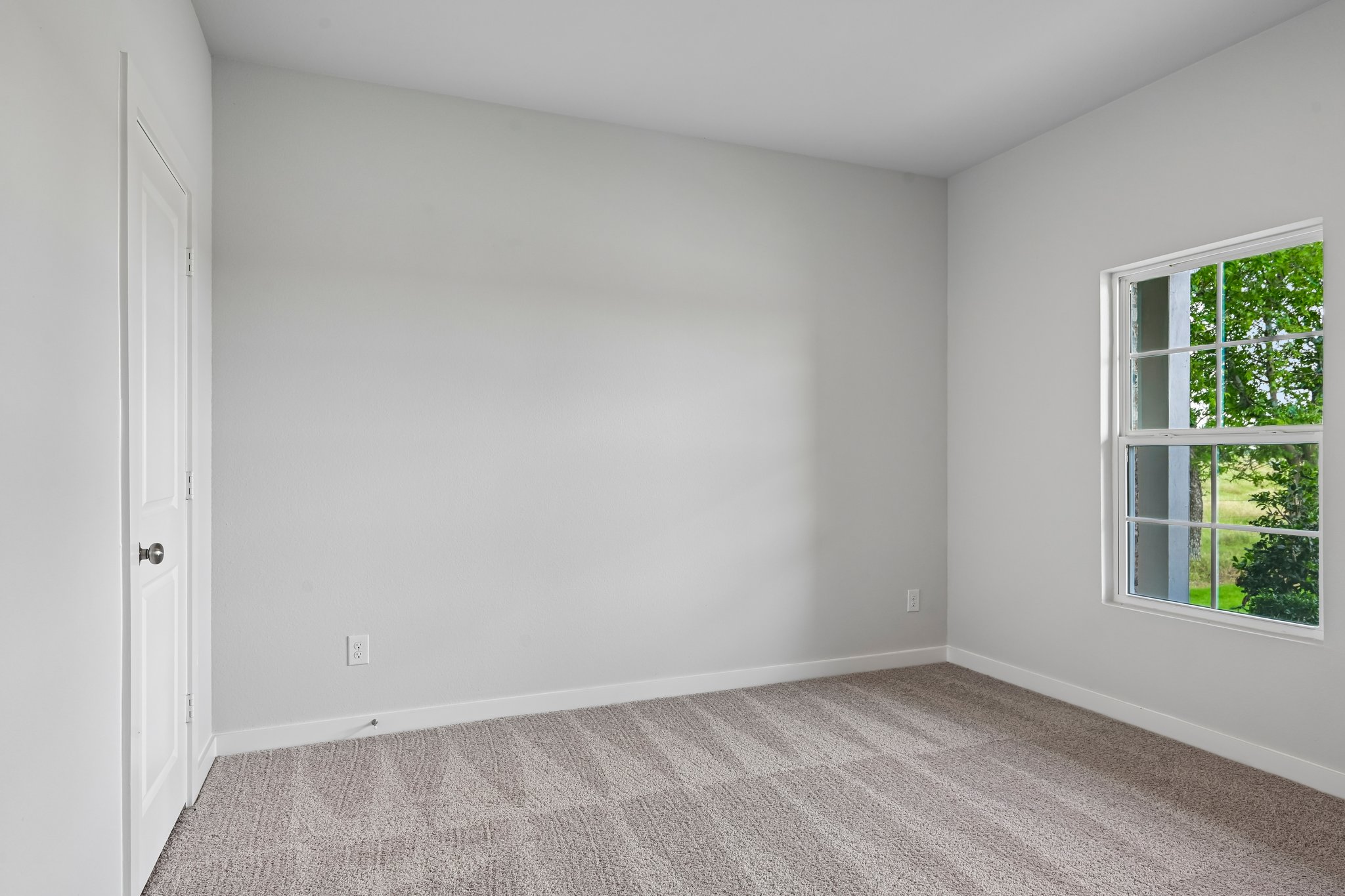 A room with a window and a carpet.