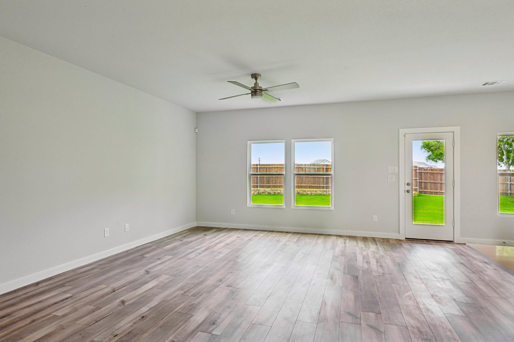 A room with a wood floor and windows.