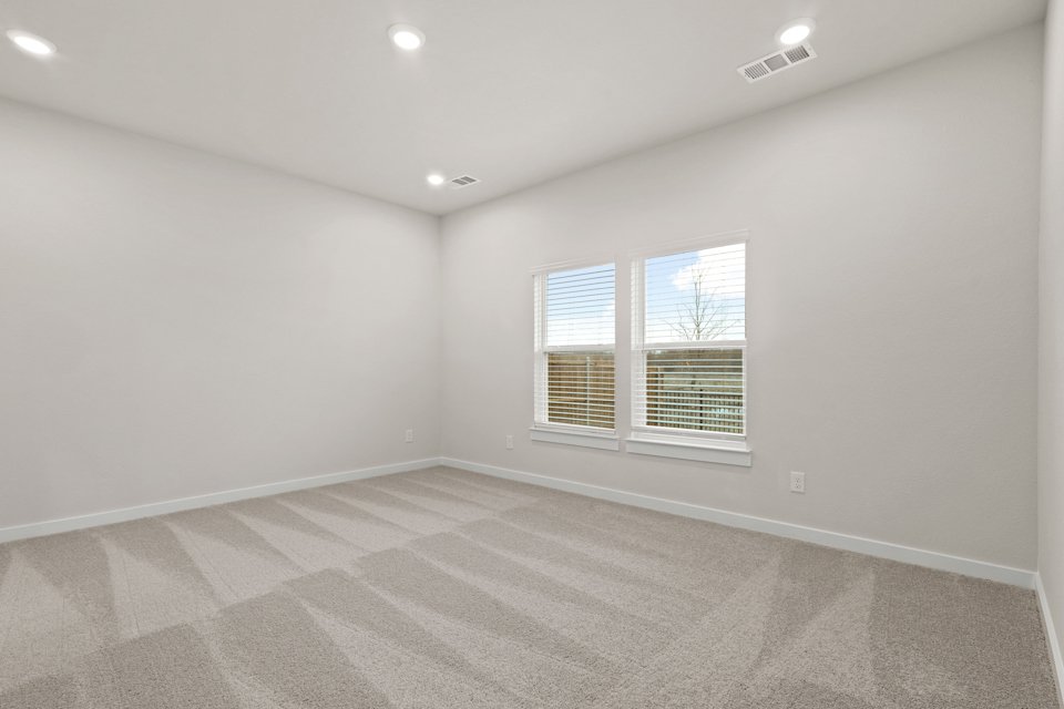 A room with a window and a rug.