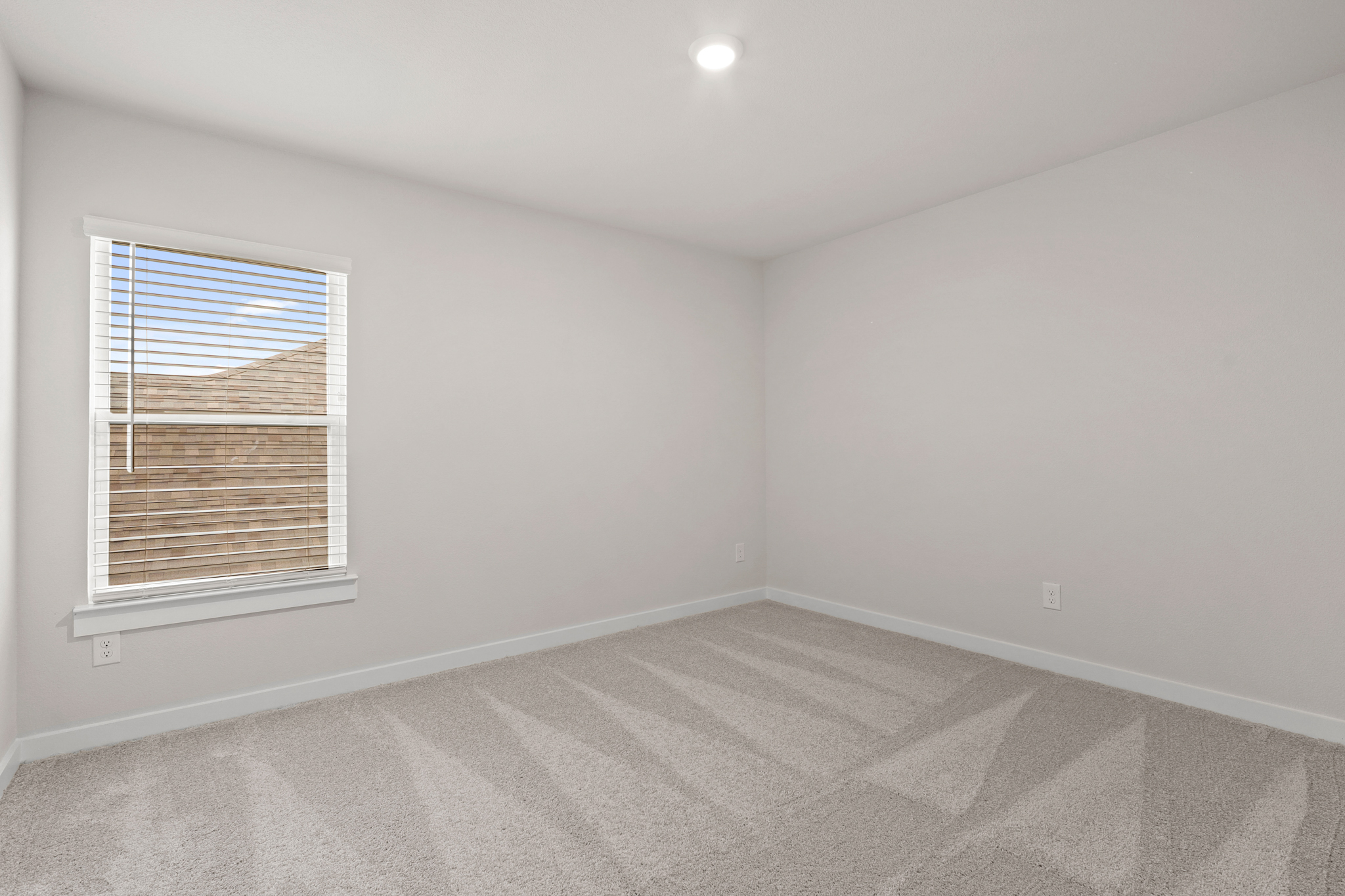 A room with a window and a carpet.